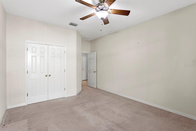 unfurnished bedroom featuring a closet, ceiling fan, and light colored carpet