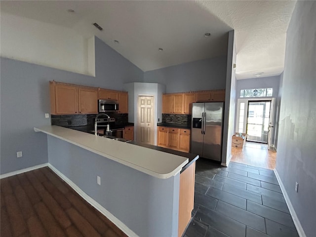 kitchen featuring kitchen peninsula, high vaulted ceiling, sink, and appliances with stainless steel finishes