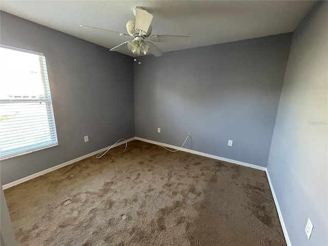 empty room featuring ceiling fan and carpet