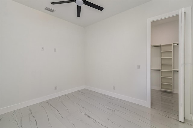 unfurnished bedroom with ceiling fan, a walk in closet, and a closet