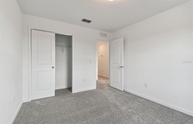 unfurnished bedroom with carpet flooring and a closet