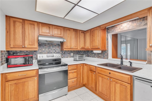 kitchen with backsplash, sink, light tile patterned flooring, and appliances with stainless steel finishes