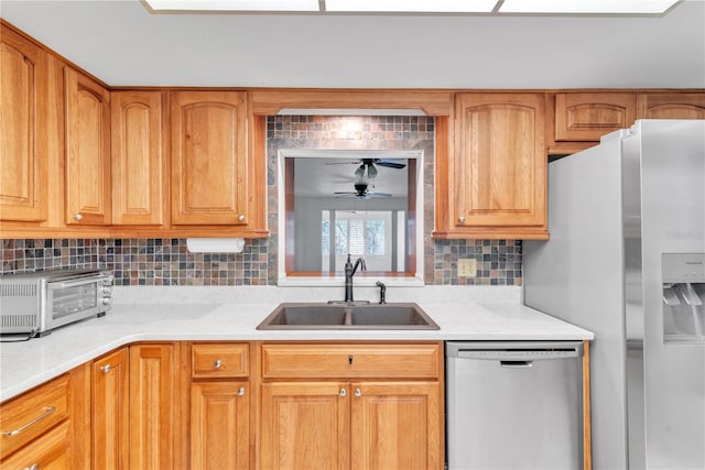 kitchen with backsplash, stainless steel appliances, ceiling fan, and sink