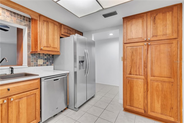 kitchen with ceiling fan, sink, decorative backsplash, light tile patterned floors, and appliances with stainless steel finishes