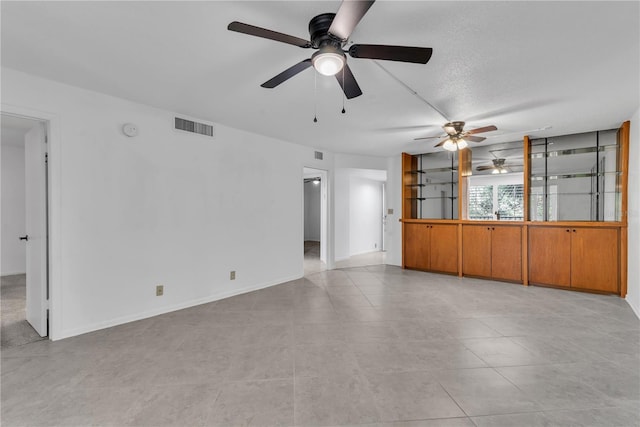 unfurnished living room with light tile patterned floors and a textured ceiling