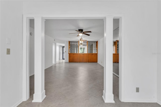 unfurnished living room featuring decorative columns, ceiling fan, and light tile patterned flooring