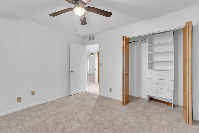 unfurnished bedroom featuring ceiling fan, light colored carpet, and a closet