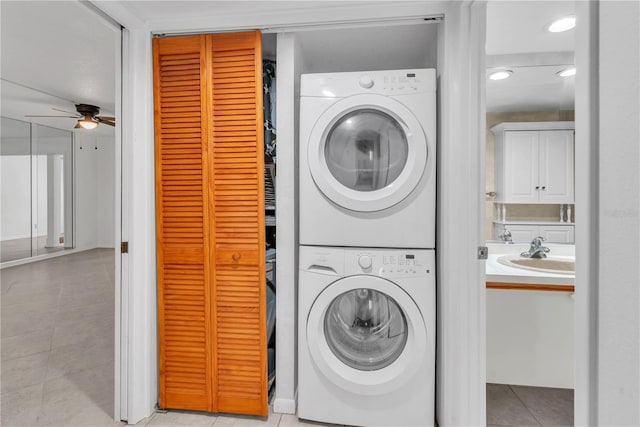 washroom featuring light tile patterned floors, stacked washing maching and dryer, ceiling fan, and sink