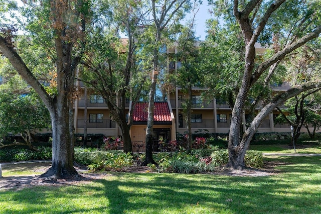 view of front of house with a balcony and a front lawn