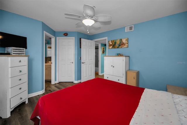 bedroom featuring ceiling fan, dark hardwood / wood-style floors, and ensuite bath