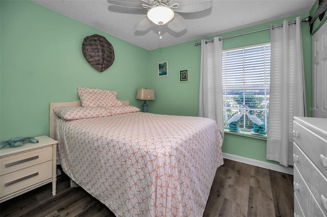 bedroom featuring ceiling fan, dark hardwood / wood-style flooring, and a textured ceiling