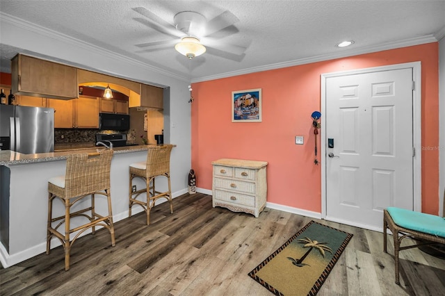 kitchen with kitchen peninsula, a breakfast bar, stainless steel appliances, and dark hardwood / wood-style floors