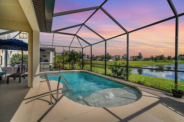 pool at dusk featuring a water view, glass enclosure, and a patio area