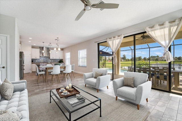 living room with light hardwood / wood-style floors, ceiling fan, and a water view