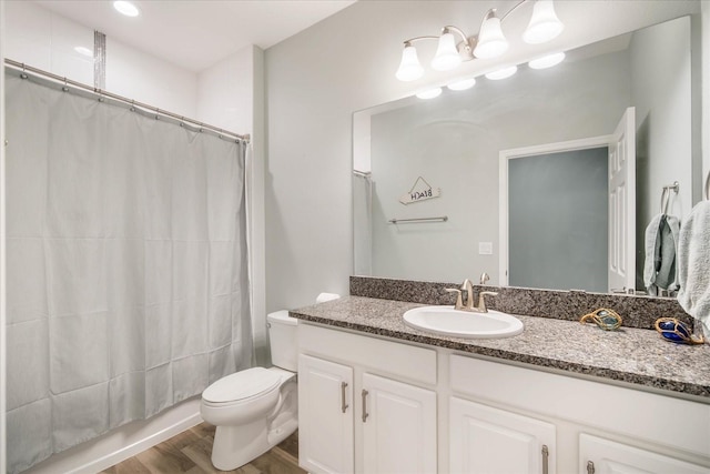 full bathroom with shower / bath combo with shower curtain, wood-type flooring, vanity, and toilet