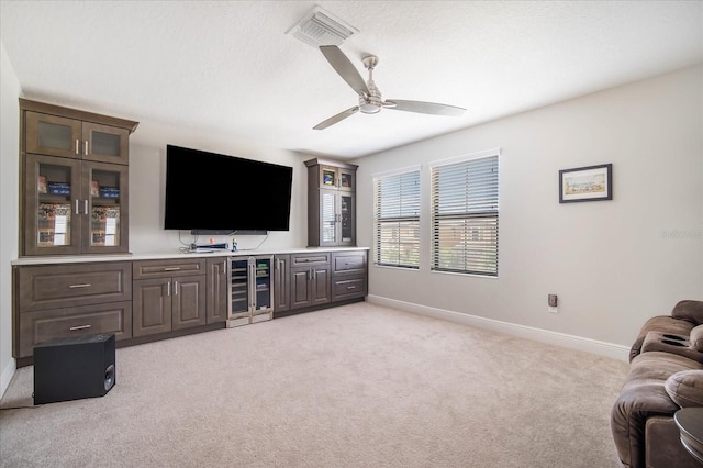 living room with beverage cooler, light carpet, and ceiling fan