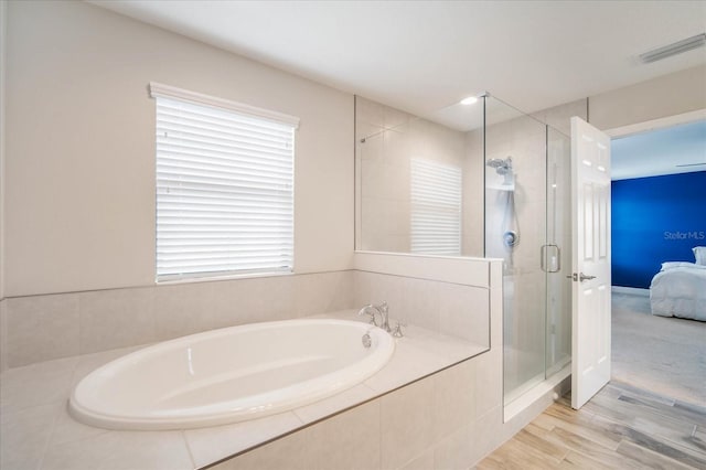 bathroom with wood-type flooring and separate shower and tub