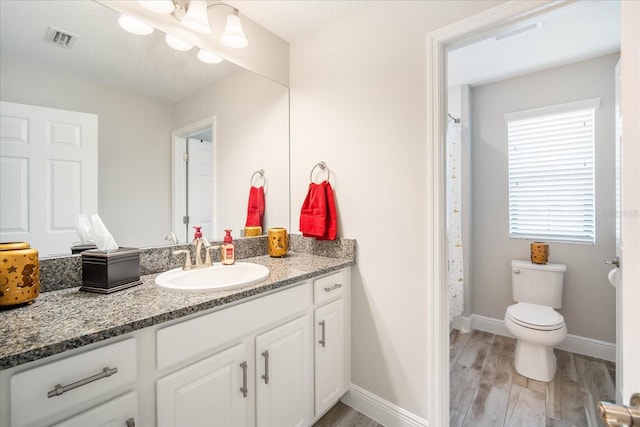 bathroom featuring hardwood / wood-style floors, curtained shower, vanity, and toilet