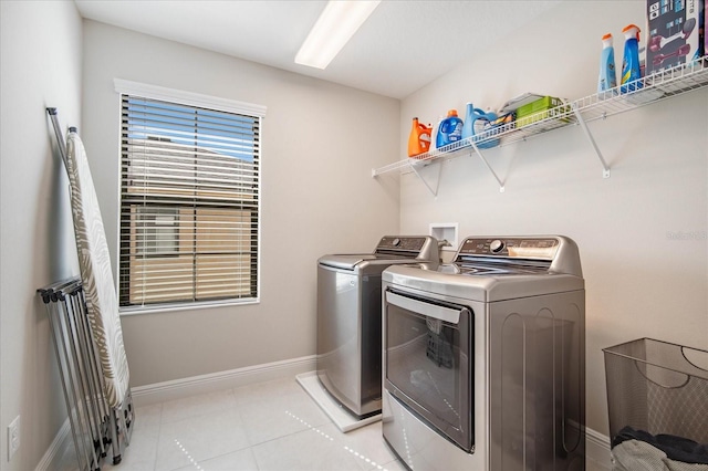 laundry room with washing machine and dryer and light tile patterned floors