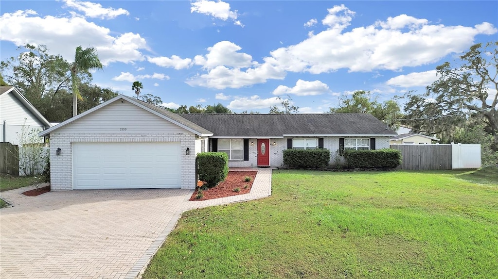 single story home featuring a garage and a front yard