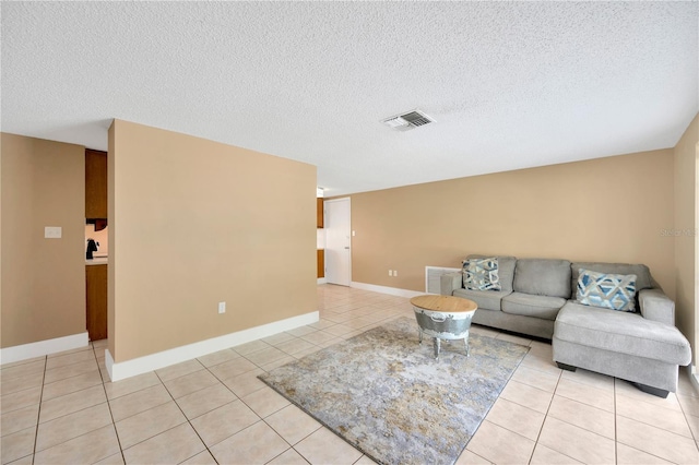 tiled living room featuring a textured ceiling