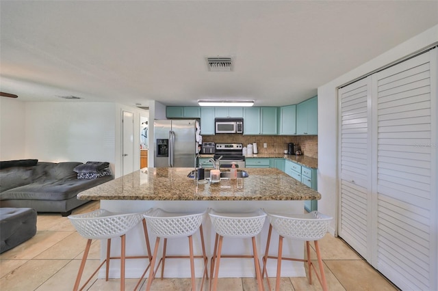3207 Acacia St, Lutz, FL 33558 - kitchen featuring appliances with stainless steel finishes, a sink, open floor plan, and a breakfast bar