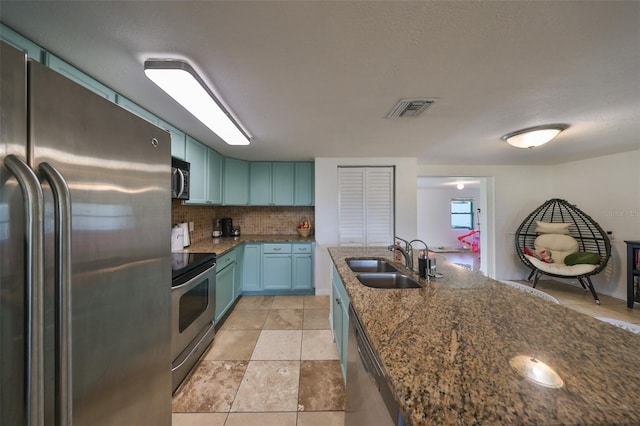 3207 Acacia St, Lutz, FL 33558 - kitchen with appliances with stainless steel finishes, a sink, tasteful backsplash, dark stone counters, and blue cabinets