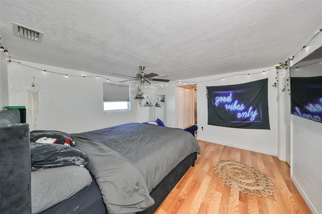 3207 Acacia St, Lutz, FL 33558 - bedroom featuring a textured ceiling, light wood-style floors, and ceiling fan