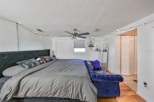 bedroom featuring a textured ceiling, hardwood / wood-style floors, and ceiling fan