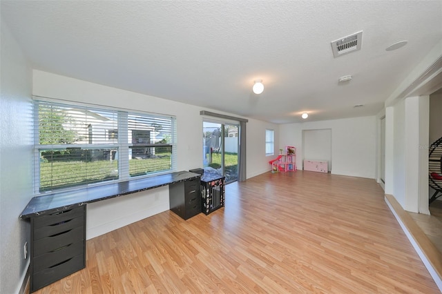 3207 Acacia St, Lutz, FL 33558 - office area with light wood-type flooring, built in desk, baseboards, and a textured ceiling