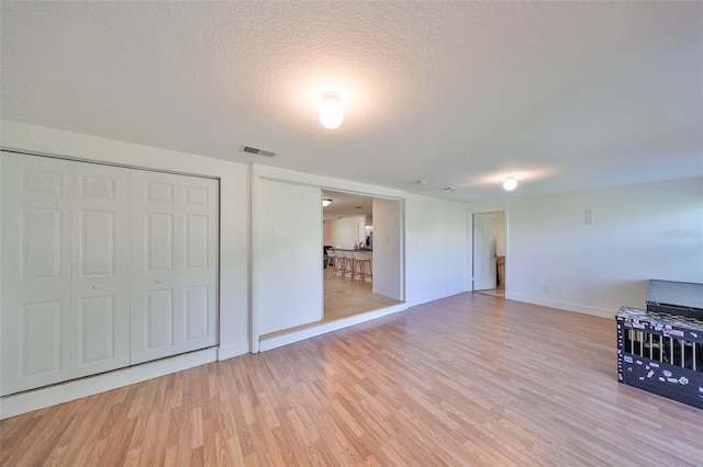 3207 Acacia St, Lutz, FL 33558 - unfurnished living room with light wood-type flooring, baseboards, and a textured ceiling