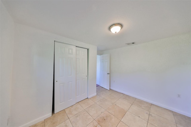 3207 Acacia St, Lutz, FL 33558 - unfurnished bedroom featuring baseboards, a closet, and light tile patterned flooring