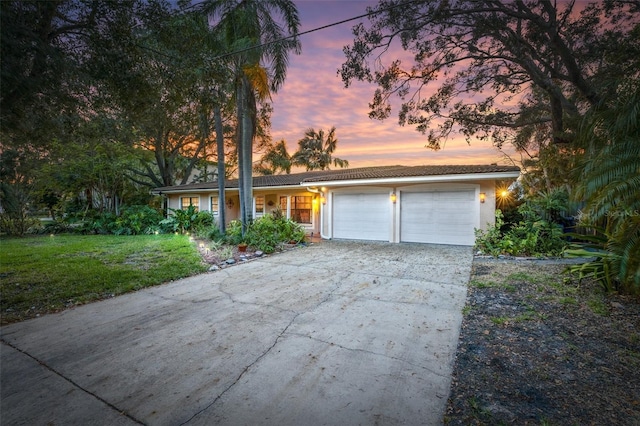 ranch-style house featuring a yard and a garage