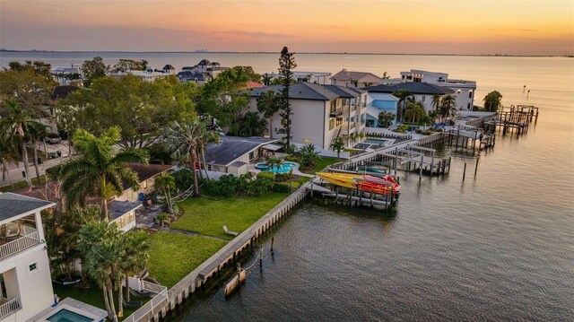 aerial view at dusk featuring a water view