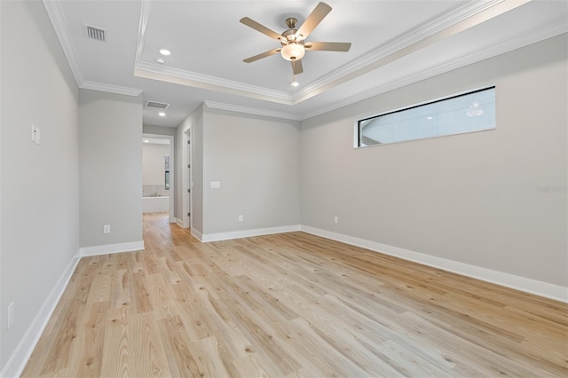 unfurnished room with ceiling fan, light hardwood / wood-style floors, ornamental molding, and a raised ceiling