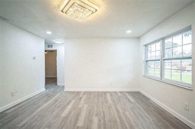 unfurnished room with light wood-type flooring