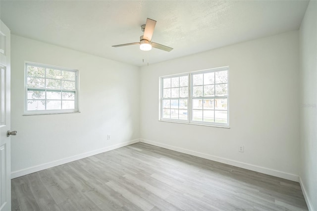 unfurnished room with ceiling fan, light hardwood / wood-style floors, and a healthy amount of sunlight