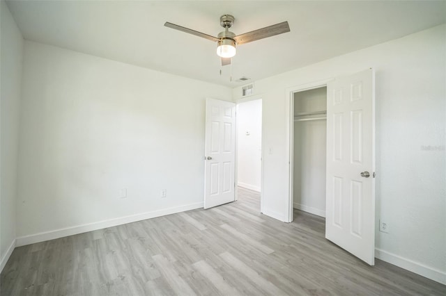 unfurnished bedroom with light wood-type flooring, ceiling fan, and a closet