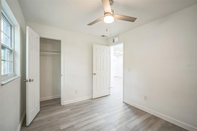 unfurnished bedroom featuring light hardwood / wood-style floors, ceiling fan, and a closet