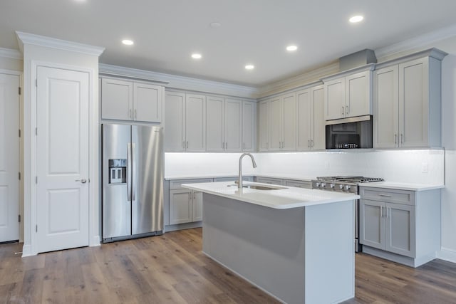 kitchen with appliances with stainless steel finishes, gray cabinets, sink, and hardwood / wood-style flooring