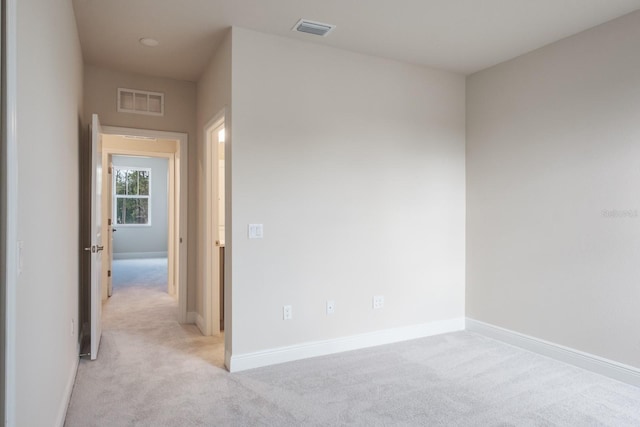 unfurnished room featuring light carpet