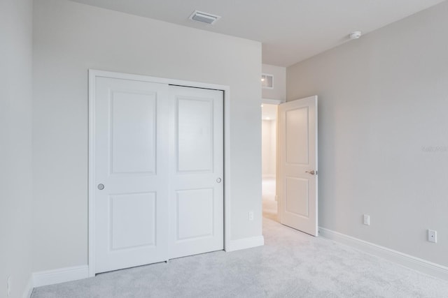 unfurnished bedroom featuring a closet and light carpet