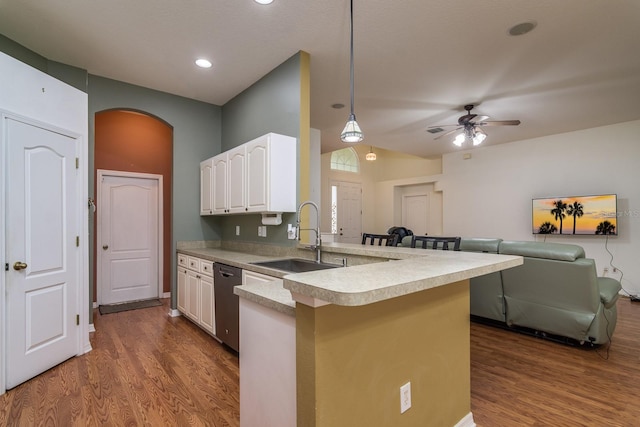 kitchen featuring sink, kitchen peninsula, dark hardwood / wood-style floors, decorative light fixtures, and stainless steel dishwasher