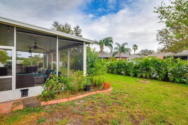 view of yard featuring a sunroom and ceiling fan