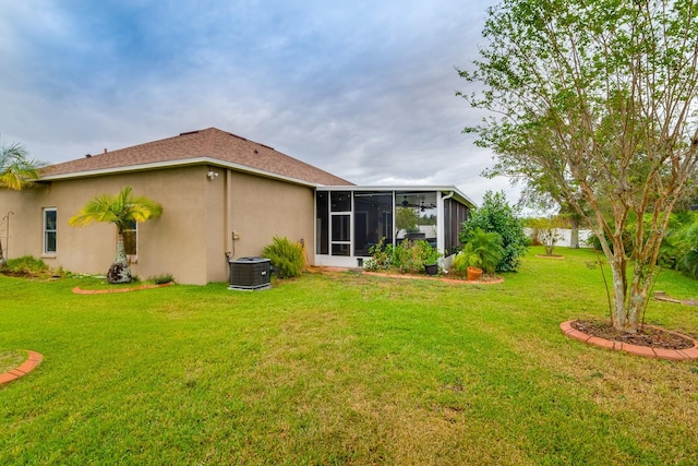 back of house featuring central air condition unit, a lawn, and a sunroom