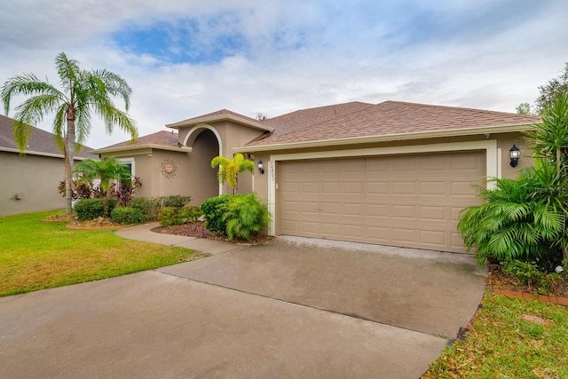 mediterranean / spanish-style house with a garage and a front lawn