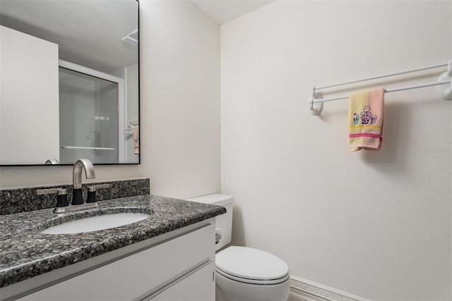 bathroom with vanity, toilet, and an enclosed shower