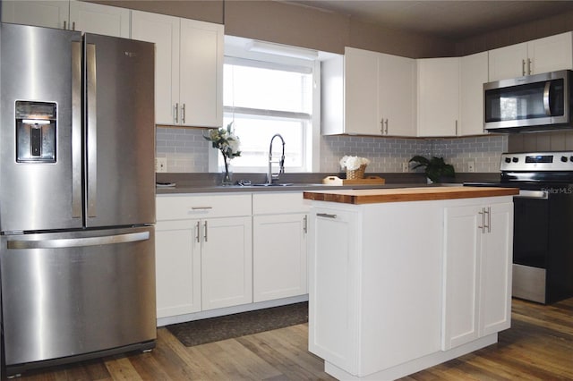 kitchen with white cabinetry, appliances with stainless steel finishes, dark wood-type flooring, and tasteful backsplash