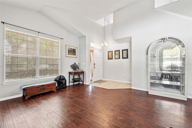 entryway featuring wood-type flooring, lofted ceiling, and a notable chandelier