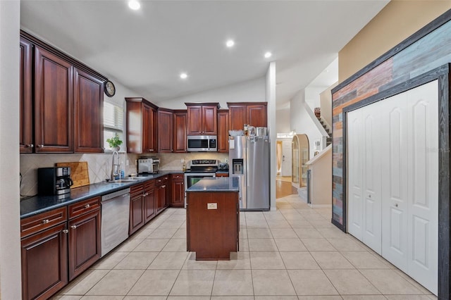 kitchen with stainless steel appliances, lofted ceiling, a center island, sink, and light tile patterned floors